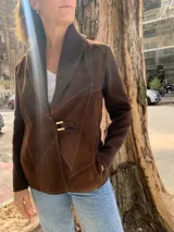Chaqueta marrón de gamuza y lana tejida, con cuello tejido y cierre frontal con hebilla dorada.