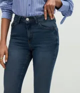 Pantalón bootcut de tiro alto confeccionado en jean de algodón con elastano. Presenta trabillas en la cintura, cierre frontal con botón, bolsillos clásicos con bolsillo reloj y bajo acampanado.
