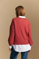 Sweater color crema con mangas abullonadas y puños elastizados. Presenta una textura tejida en relieve con patrón de ladrillos en el cuerpo y rayas horizontales en las mangas.