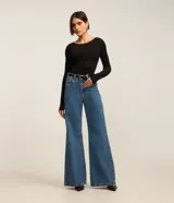 Suéter de tricot negro con cuello redondo y mangas largas. Presenta un diseño ajustado al cuerpo con textura de frisos verticales.