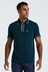 Polo de manga corta color verde oscuro, con cuello y puños acanalados con detalle de líneas blancas. Presenta cierre frontal de tres botones y un bolsillo en el pecho con el logo de la marca bordado.