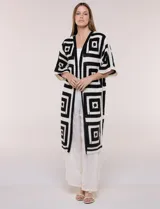 Cardigan largo de punto crochet en blanco y negro, con diseño geométrico de cuadrados, mangas amplias tipo kimono y frente abierto.
