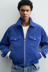 Sobrecamisa regular fit de Zara, confeccionada en pana de algodón color azul con efecto lavado. Cuenta con cuello solapa, manga larga con puño y botón a presión, bolsillos frontales de plastrón con solapa y cierre de cremallera.