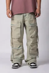 Jean de corte baggy con múltiples bolsillos cargo frontales con cierre metálico, tiro medio y tiras de ajuste en la botamanga.