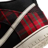 Zapatillas Nike Dunk High Retro SE, con diseño a cuadros tartán en negro, rojo y verde, detalles en cuero rojo y logo Nike en blanco.
