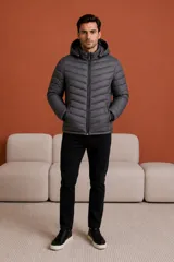Campera puffer negra con capucha, cierre frontal completo y bolsillos laterales con cierre. Diseño acolchado con costuras horizontales.