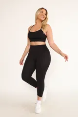 Calza capri negra de tiro alto confeccionada en tejido de punto de alta densidad.