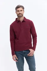 Remera polo de manga larga color bordó, confeccionada en algodón. Presenta cuello clásico con cierre de botones y detalle de logo bordado en el pecho.