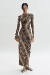 Vestido largo de malla de doble capa con estampado de piel de serpiente. Modelo entallado de manga larga, con escote redondo y detalle de costura fruncida lateral que crea un efecto drapeado.
