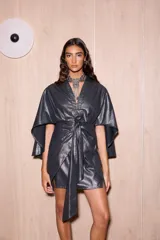 Vestido corto tipo kimono, color negro con brillo metálico (lurex), con mangas amplias y tiras ajustables en la cintura.