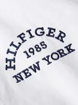 Camisa blanca de corte regular y manga larga, con logo bordado en el pecho y botón a contraste.