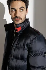 Campera puffer color verde militar, con cuello alto y cierre frontal.