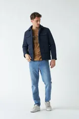 Campera negra de nylon capitoneada, con cuello medio y bolsillos tipo sobre con botón.