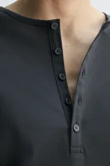 Camiseta de manga larga con cuello panadero y cierre frontal de botonadura, de corte relajado.
