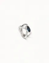 Anillo plateado con forma de pata de araña cruzada y una caja ovalada con un cristal azul.