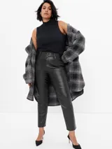 Pantalón de tiro alto con efecto cuero, corte slim y diseño vintage con cinco bolsillos y cierre frontal con botón y cremallera.