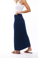 Falda midi de jean azul oscuro, con corte recto, abertura frontal y cierre con botones metálicos.