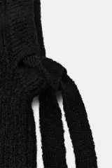 Capucha de punto canalé color negro, con diseño envolvente y cierre frontal ajustable mediante lazada a tono.