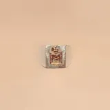Anillo de sello con cuerpo de plata 925 y aplique central de oro 9k con el escudo de la policía. Presenta una textura rayada alrededor del emblema.