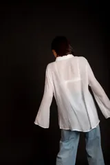 Camisa rosada con detalles de broderie en la parte delantera y mangas anchas.