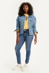 Jean de corte skinny y tiro alto, confeccionado en denim azul con lavado medio. Presenta diseño clásico de cinco bolsillos y cierre frontal con botón y cremallera.