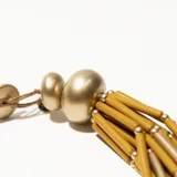 Collar corto de cuentas tubulares negras y plateadas, con esferas plateadas en los extremos.