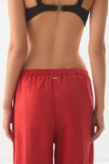 Pantalon de corte recto y holgado, confeccionado en una mezcla de lino y algodón. Presenta una cintura elástica con cordón ajustable y bolsillos laterales.