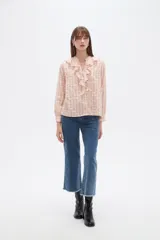 Blusa de viscosa con estampado de cuadros y pequeños puntos, diseño holgado, cuello a la base con volados frontales, cierre de botones y mangas largas con puños.