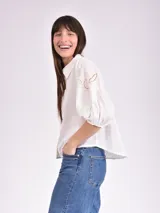 Camisa blanca de mangas 3/4 con detalles de calado en los hombros.