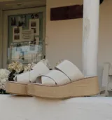 Sandalias con plataforma de yute y tiras cruzadas de charol color marfil.