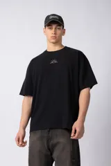 Remera color crudo de corte oversize, con cuello redondo y mangas cortas. Presenta un pequeño bordado de un sol en el centro del pecho.