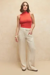 Pantalón de tiro alto color beige, de tela liviana, con cinto incluido y bolsillos en los laterales.