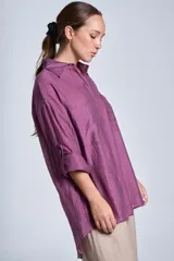 Camisa negra de tela traslúcida con cuello clásico, cierre frontal con botones y dos bolsillos de parche en el pecho.