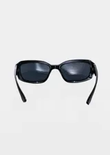 Lentes de sol rectangulares con armazón de plástico blanco y cristales marrones.