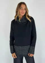 Sweater negro con cuello alto tipo drapeado y puños y dobladillo con tejido brillante en tonos grises.