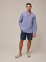 Camisa de manga larga para hombre, confeccionada en algodón con efecto peach (textura suave). Presenta un estampado de cuadros vichy en tonos azul marino y blanco, cuello con botones y un bolsillo de parche en el pecho izquierdo.