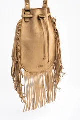 Cartera tipo bucket bag color camel, confeccionada en material sintético con acabado gamuzado. Presenta un diseño decorado con flecos largos en todo el contorno, cierre mediante cordón ajustable y correa larga regulable.
