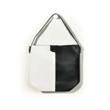 Cartera tipo tote bag de cuero sintético, dividida en dos secciones verticales de color blanco y negro. Tiene correa de hombro y cierre con broche imantado.