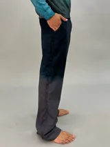 Pantalón de lana color gris oscuro con corte recto y detalle texturizado en las piernas laterales. Tiene pretina elástica a la cintura y un teñido degradé. Es parte del conjunto Alquimia.