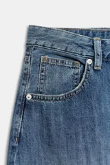 Jeans de tiro medio y diseño balloon, color azul denim con efecto lavado, cinco bolsillos, cierre frontal con cremallera y botón metálico, y bajos acabados en puño.