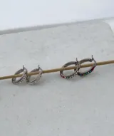 Par de aros tipo argolla de acero quirúrgico, decorados con una hilera de cristales de colores.