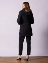 Campera capitoneada de corte largo con diseño acolchado en forma de rombos. Cuenta con cierre frontal completo, capucha desmontable, bolsillos delanteros con solapa y cierre, y forro interno a tono.