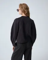 Buzo negro de punto tramado italiano con mangas voluminosas, escote redondo y detalles de bordado en sisas y recortes de manga.