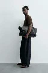 Camiseta de corte relajado (relaxed fit) color blanco roto o crema, con cuello redondo y manga corta.