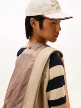 Campera estilo bomber Tommy Hilfiger color beige, con cierre frontal de cremallera, bolsillos laterales de ojal, puños y dobladillo de canalé. Cuenta con el logotipo de la marca bordado en el pecho y un parche distintivo en la manga.