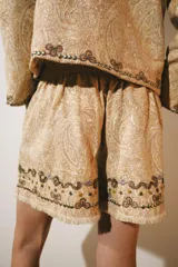 Chaqueta de hilatura de algodón en color beige, de cuello redondo y manga larga, con aplicaciones de bordados a contraste.