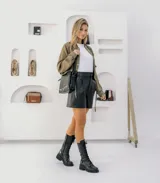 Borcego de cuero vacuno color negro, con suela de goma artesanal, caña alta con aplique capitoneado desmontable y horma de punta redonda.