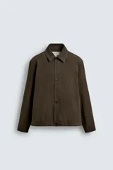 Sobrecamisa de corte regular fit confeccionada en tejido de algodón con acabado lavado. Presenta cuello solapa, cierre frontal de botones, mangas largas con puños abotonados y un bolsillo plastrón en el pecho.