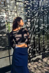 Falda larga azul de tafeta, ajustada en la cintura y con volado amplio con tajo lateral.