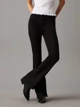 Pantalón de jean negro, de tiro alto, corte ajustado en la pierna y acampanado en el tobillo.